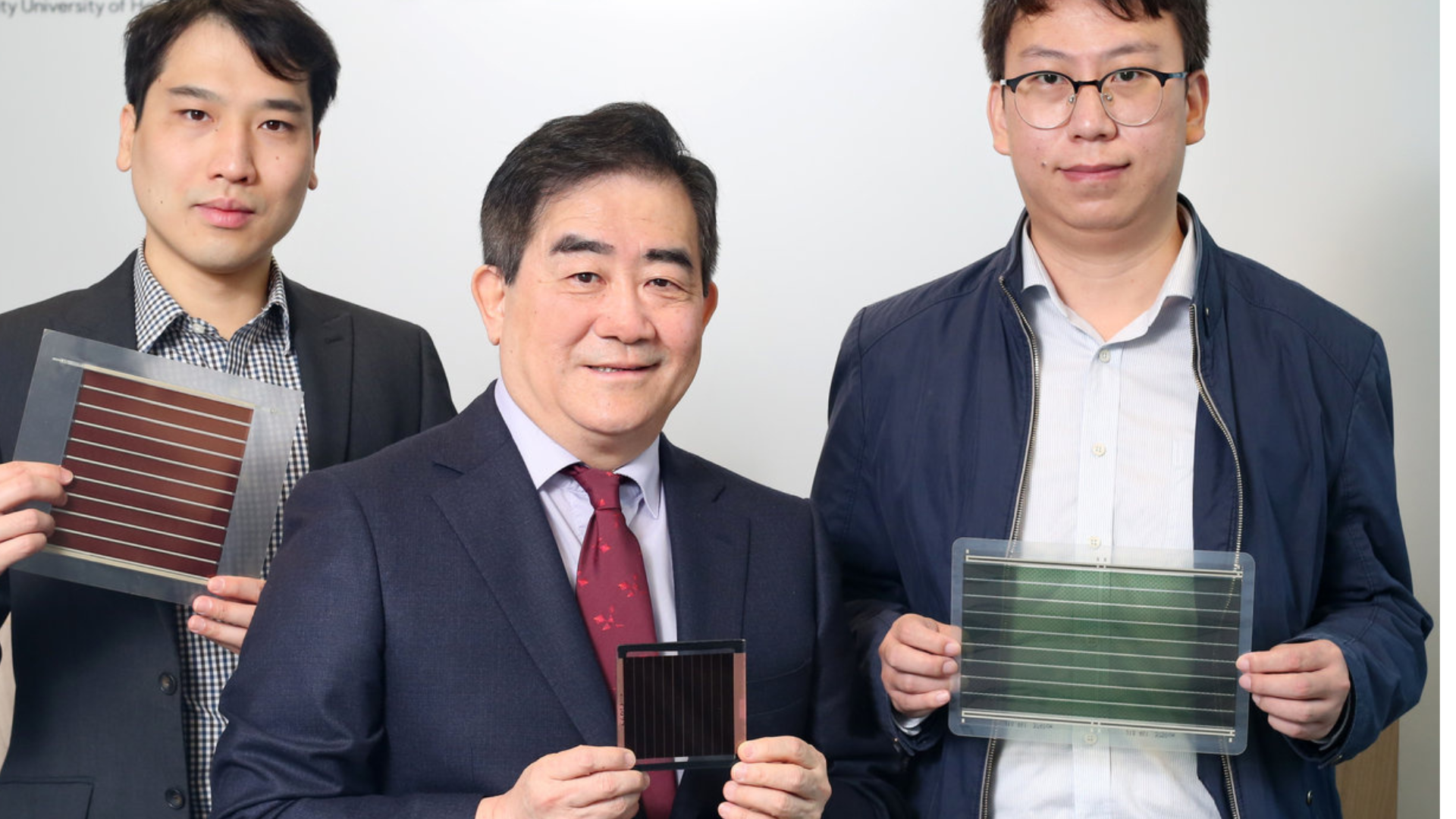 El profesor Alex Jen Kwanyue (centro) y dos miembros de su equipo de investigación de la Universidad de la Ciudad de Hong Kong (CityUHK) muestran ejemplos de células solares de perovskita de nueva generación, destacando los avances en eficiencia, estabilidad y reducción de costos de producción.