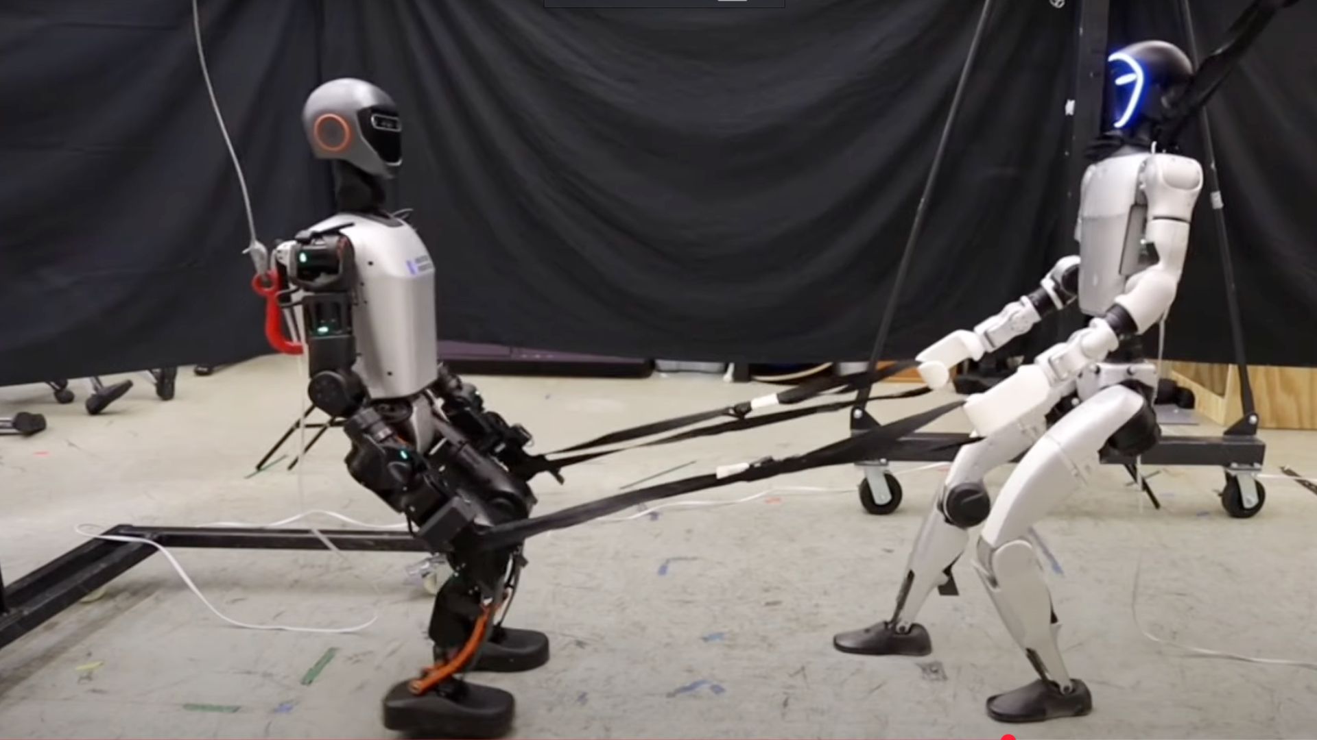 Watch humanoid robots clash in a tug of war, pull cart, open doors